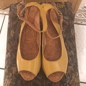 Mustard patent-leather peep toe wedge sandals.